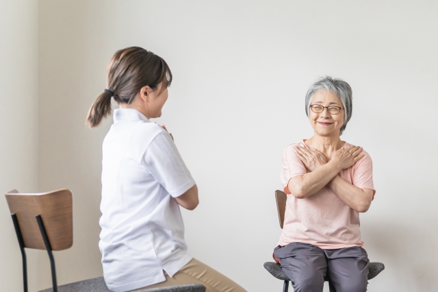 シニア女性が椅子で体操を学ぶ様子